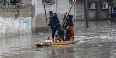 استُخدمت القوارب الخشبية للتنقل! أمطار غزيرة تغمر شوارع غزة التي دمرها العدوان الإسرائيلي 