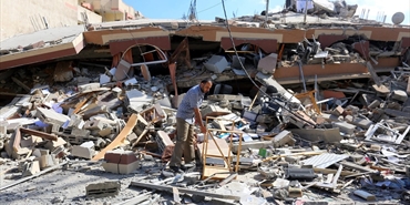 مواطنون يتفقدون اثار الدمار الذي تسببه قصف العدوان الاسرائيلي